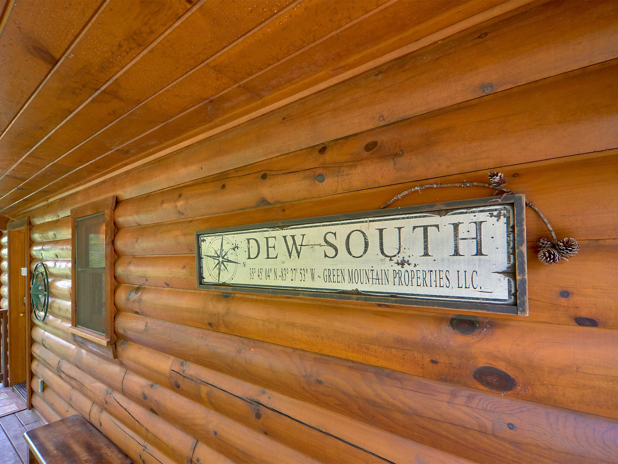 L’intérieur d’un chalet en bois, avec une enseigne indiquant « DEW SOUTH » et une rose des vents.