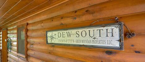 L’intérieur d’un chalet en bois, avec une enseigne indiquant « DEW SOUTH » et une rose des vents.