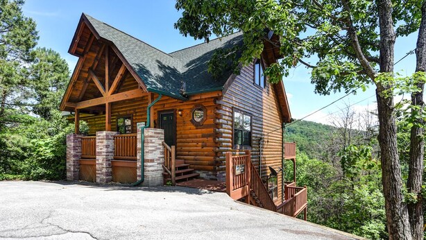 A log cabin with a porch, a staircase, and a view of the surrounding forest. - A Majestic View III by Jackson Mountain Rentals (Townsend)