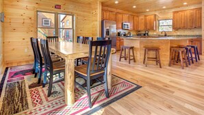 L’intérieur d’un chalet en bois comprend un coin repas, une cuisine et un bar avec des sièges.
