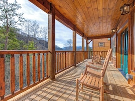 Eine Holzterrasse mit Schachbrettmuster, Holzwertlauf und Blick auf eine Berglandschaft.