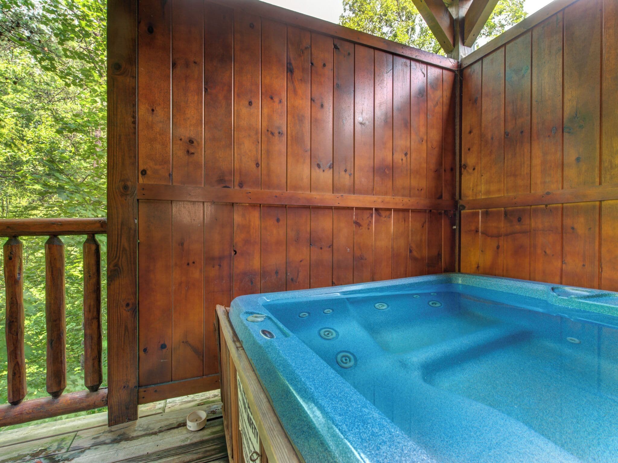Una terraza de madera con un jacuzzi.