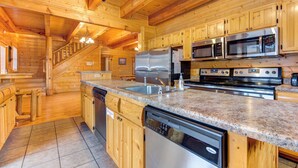 A modern kitchen with wooden cabinets, stainless steel appliances, granite countertops, and a built-in dishwasher.