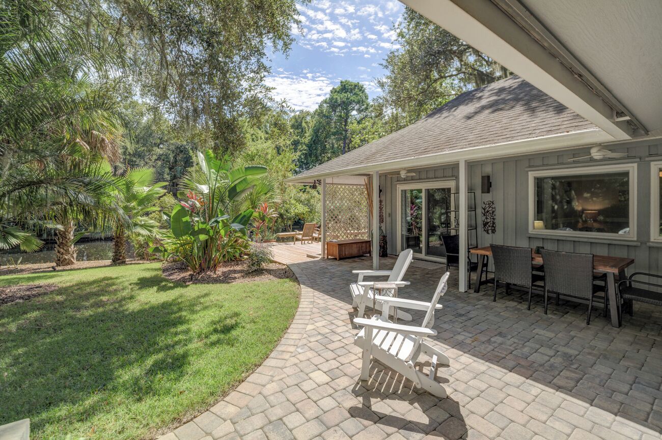 A patio with outdoor seating, a covered area, and a view of the surrounding greenery.