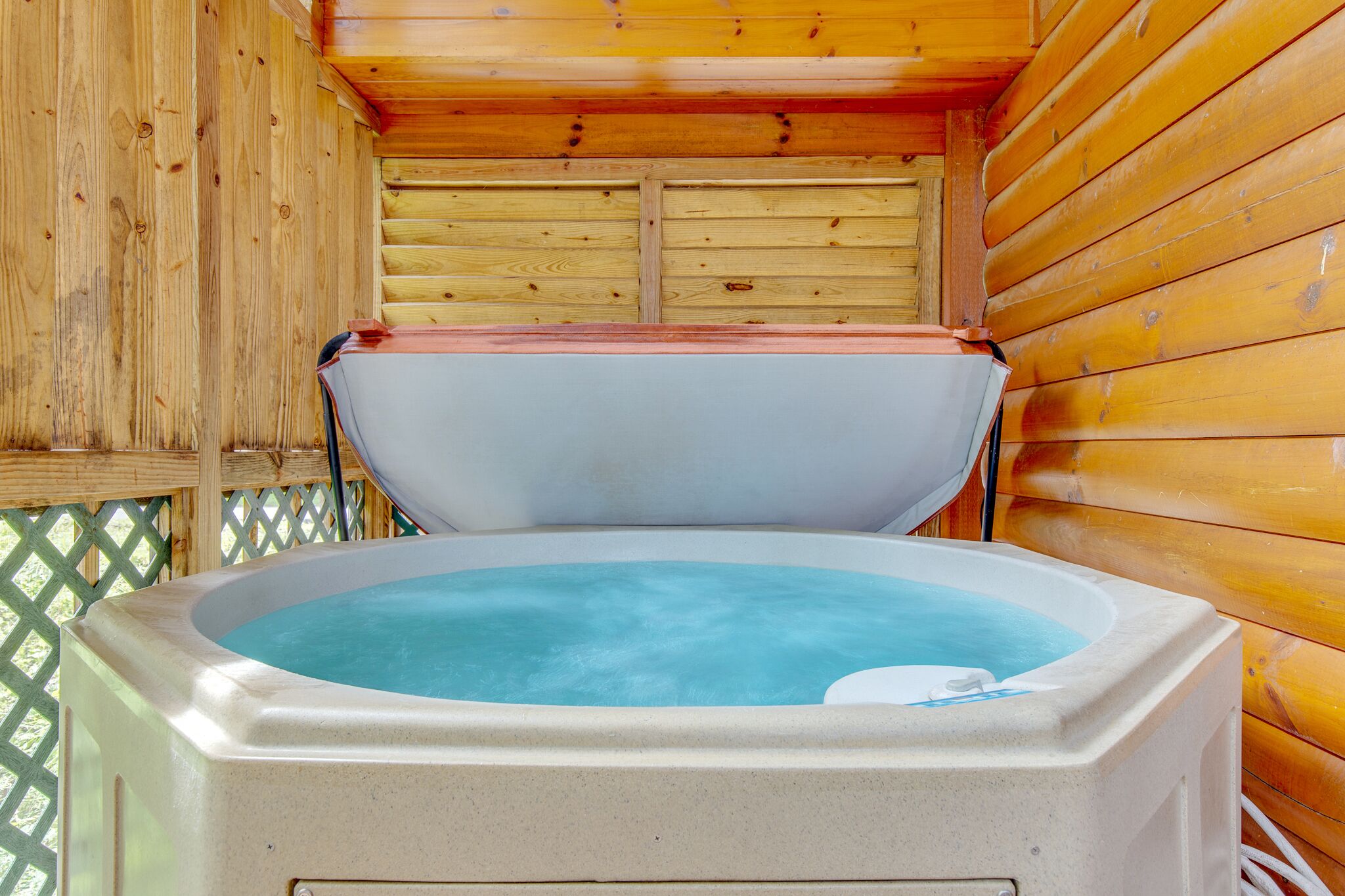 Una cabaña de madera con jacuzzi.