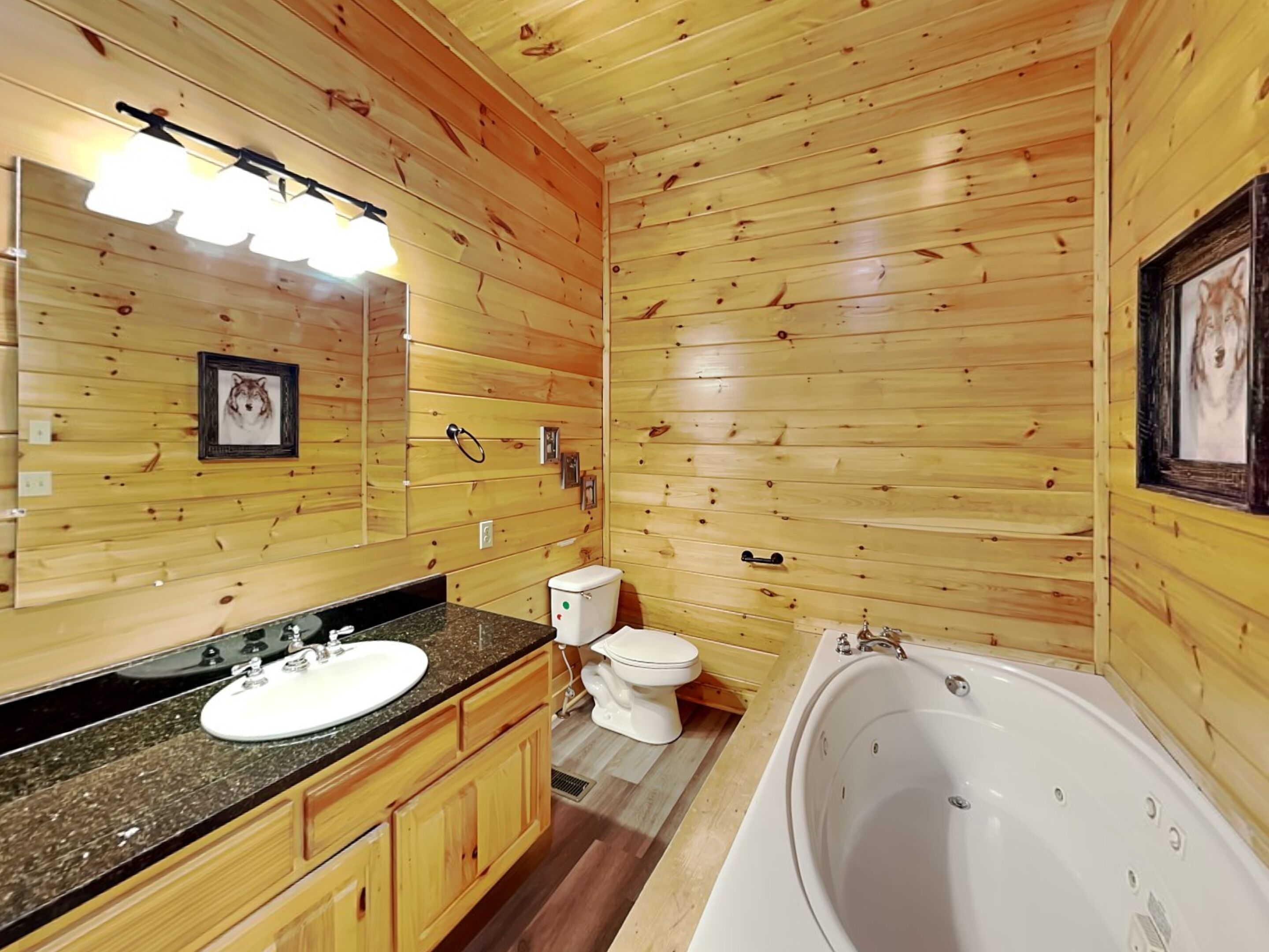 Ein Badezimmer einer Holzhütte mit Waschbecken, Toilette und Badewanne.
