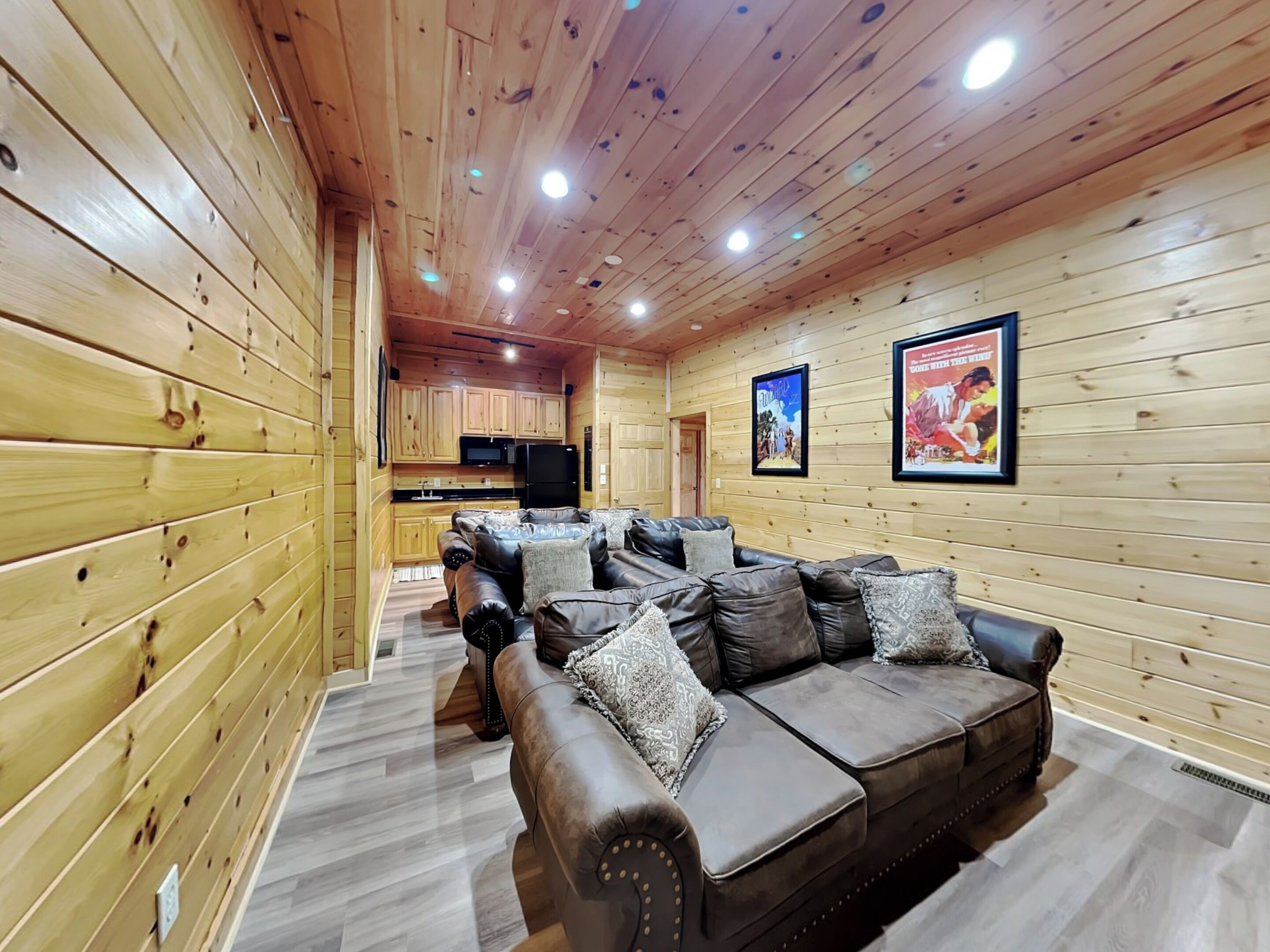 Ein rustikales Holzhaus-Interieur mit einer Ledersitzgruppe, Holzwänden und einer Küchenzeile.