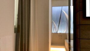 A modern bathroom with a glass shower enclosure, a visible toilet, and a mirror reflecting the room. - B&B Gassa D’Amante (Vieste)