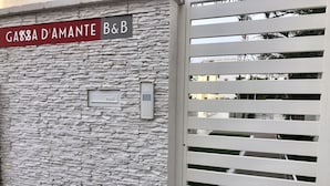 A stone wall with a sign reading "GABBA D'AMANTE B&B" and a keypad door. - B&B Gassa D’Amante (Vieste)
