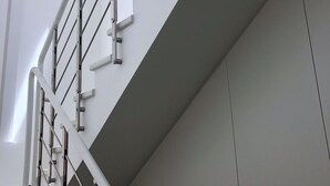 A modern staircase with metal railings and a white wall. - B&B Gassa D’Amante (Vieste)