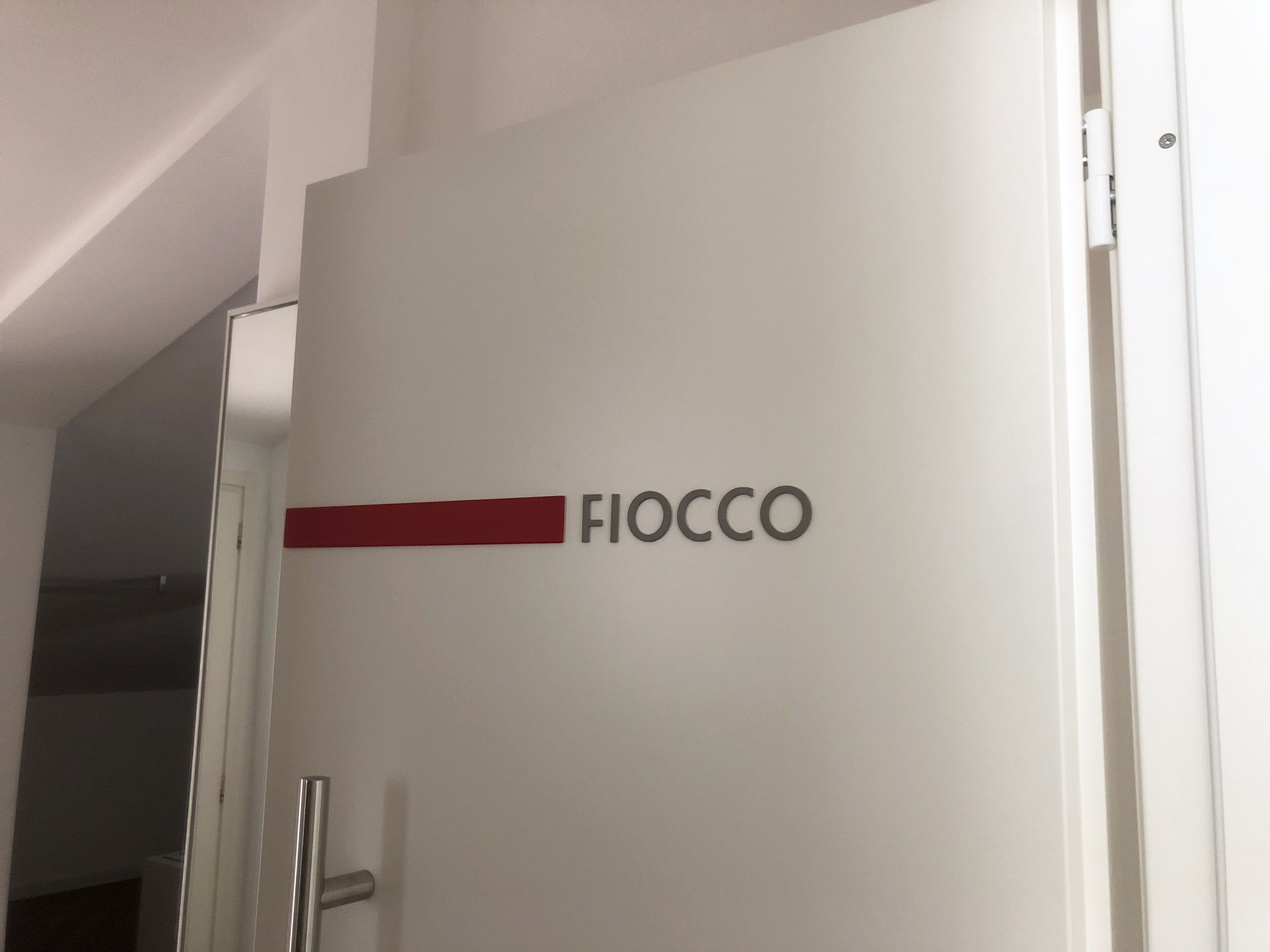 A white door with the name "FIOCCO" in black letters and a red accent.