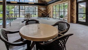 A spacious indoor area with a pool, wooden ceiling, and large windows offering views of the outside. - Summit of Gatlinburg by Jackson Mountain Rentals (Gatlinburg)