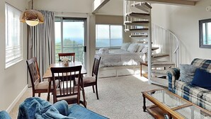A spacious living area with a dining table, chairs, a sofa, a staircase, and a view of the outdoors. - Summit of Gatlinburg by Jackson Mountain Rentals (Gatlinburg)