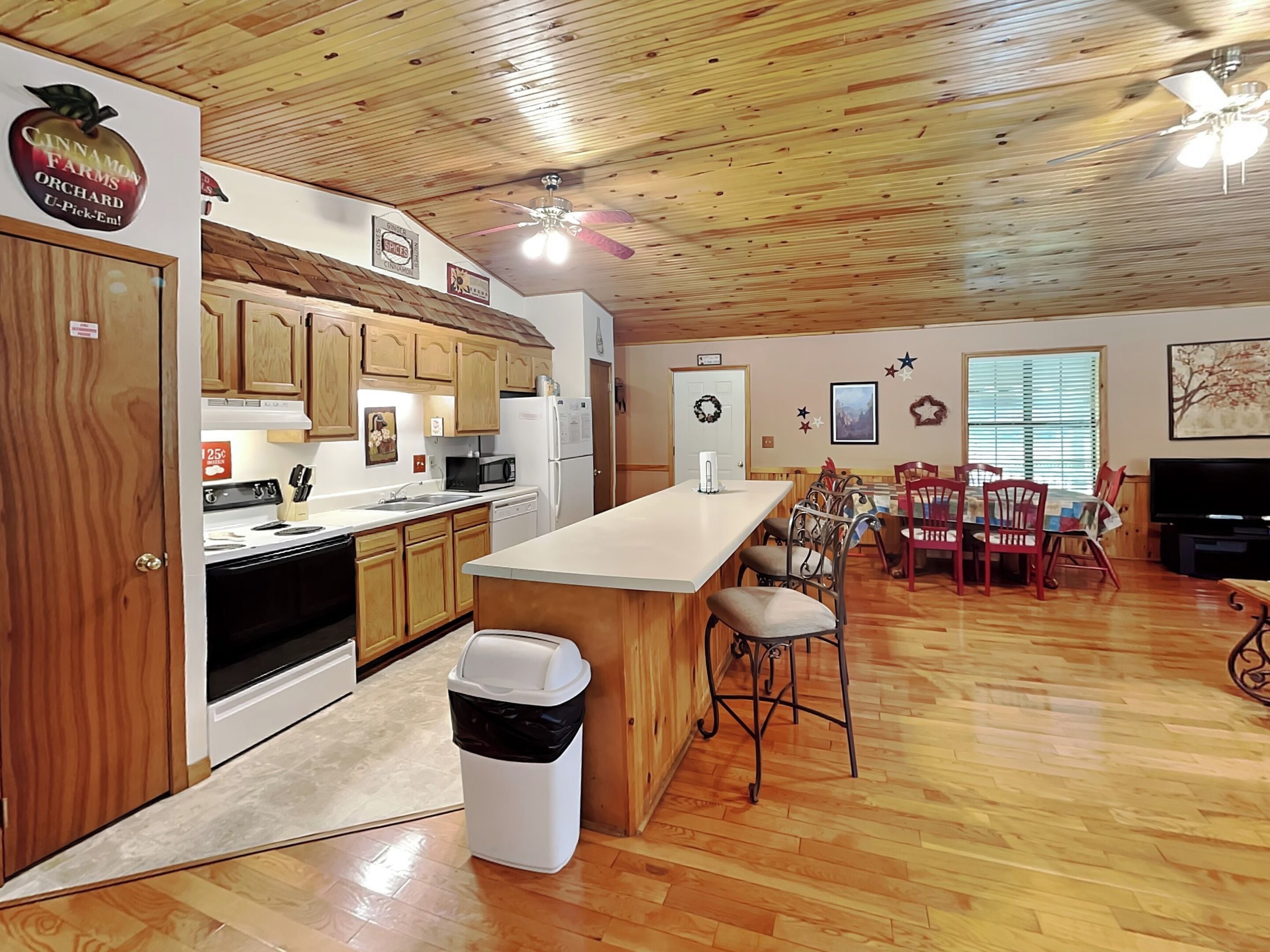 A spacious kitchen with wooden cabinets, a central island, and a dining area with a table and chairs.
