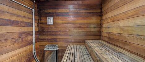 A sauna room with wooden walls and benches.