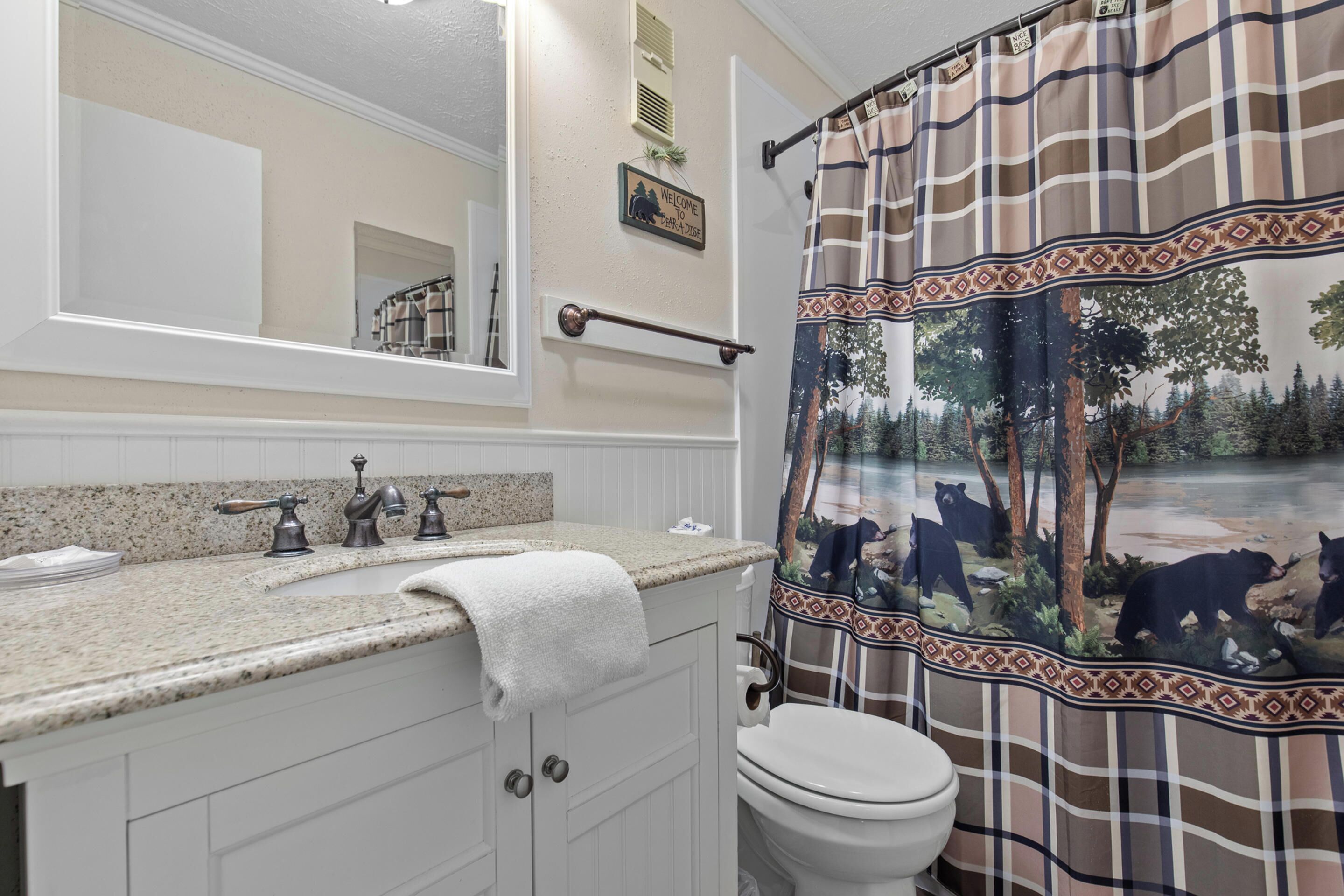 A bathroom with a sink, mirror, towel rack, and toilet.