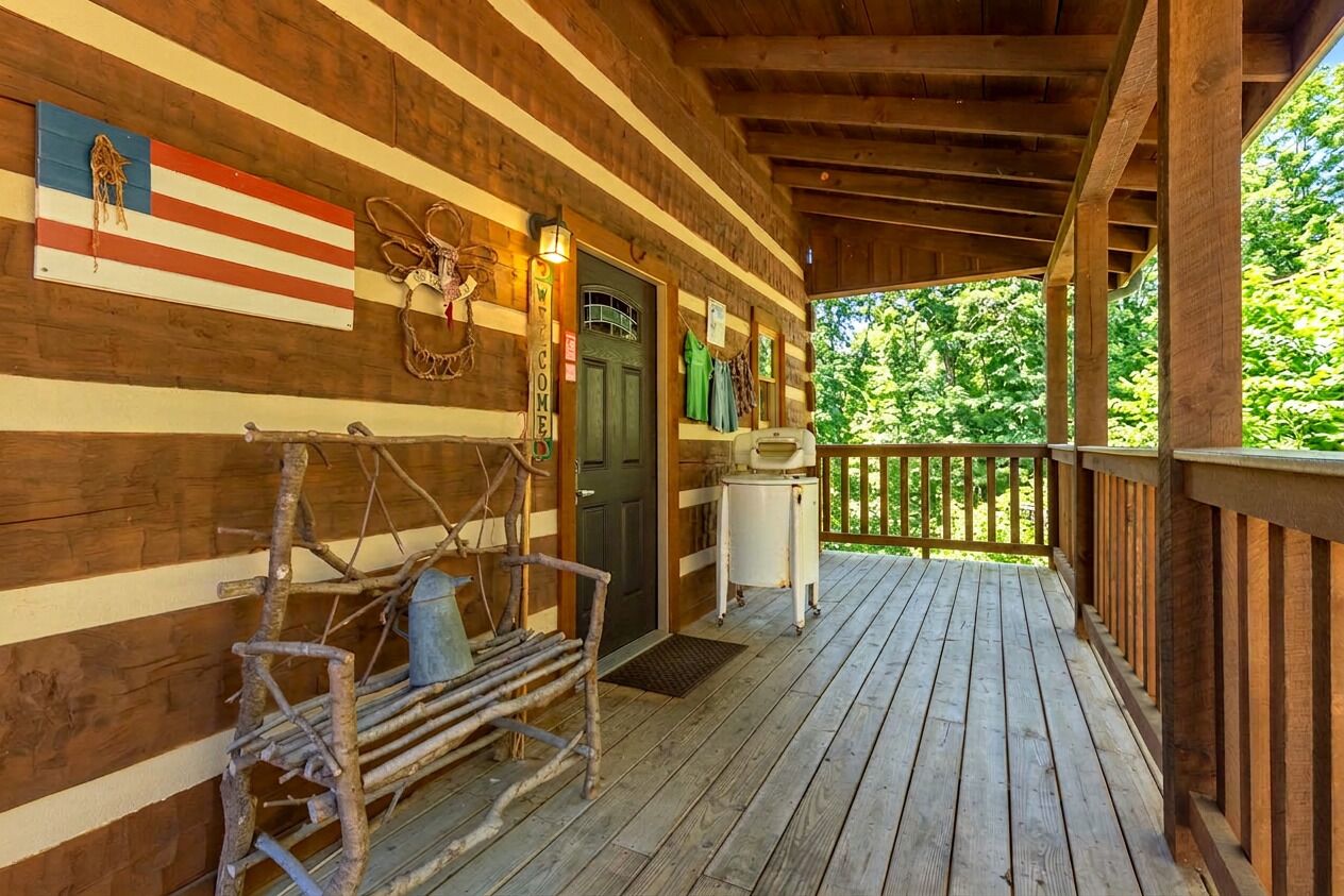 Eine Holzhütte mit Veranda, einem Willkommensschild und einer Flagge.