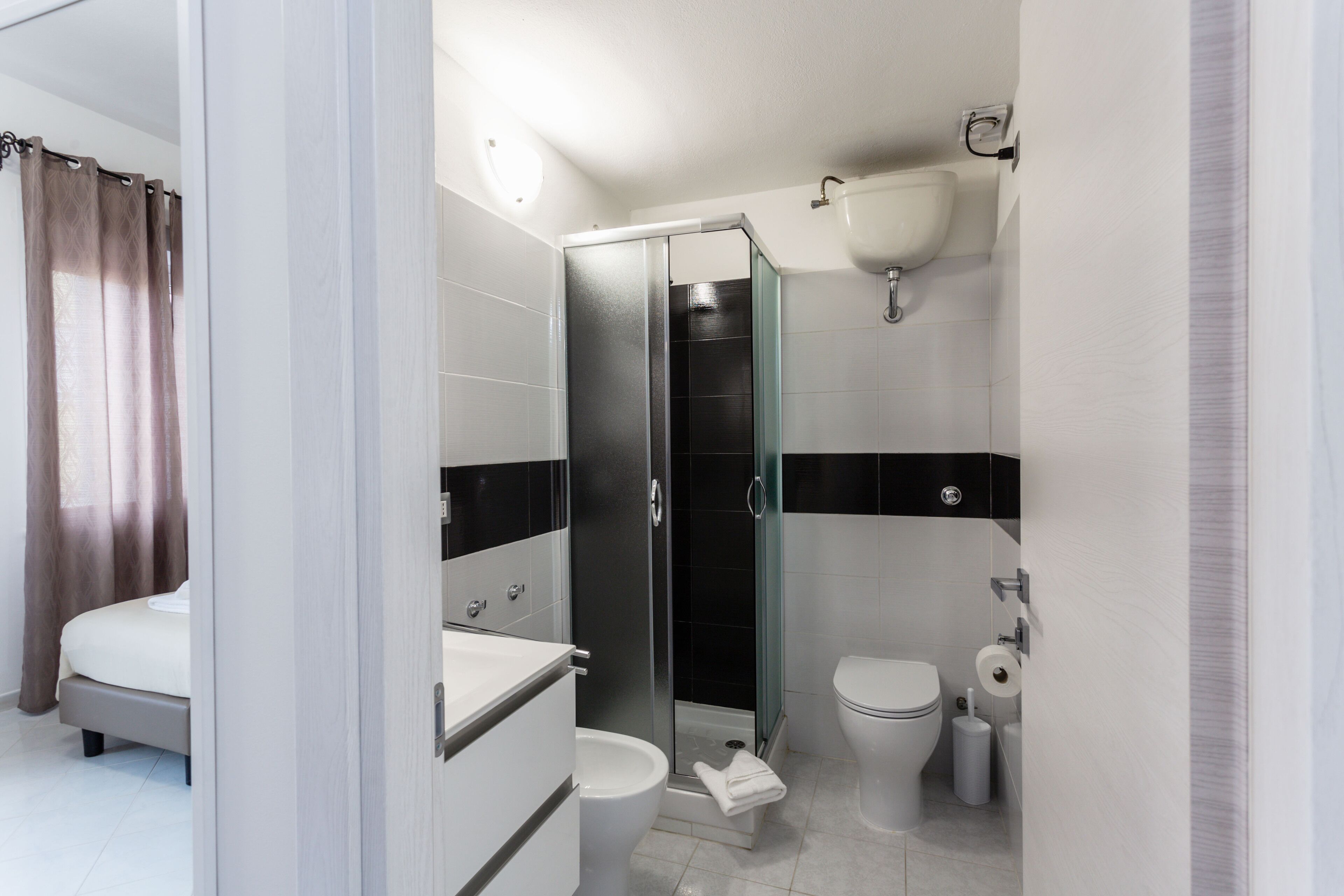 Een moderne badkamer met douche, toilet en wastafel.