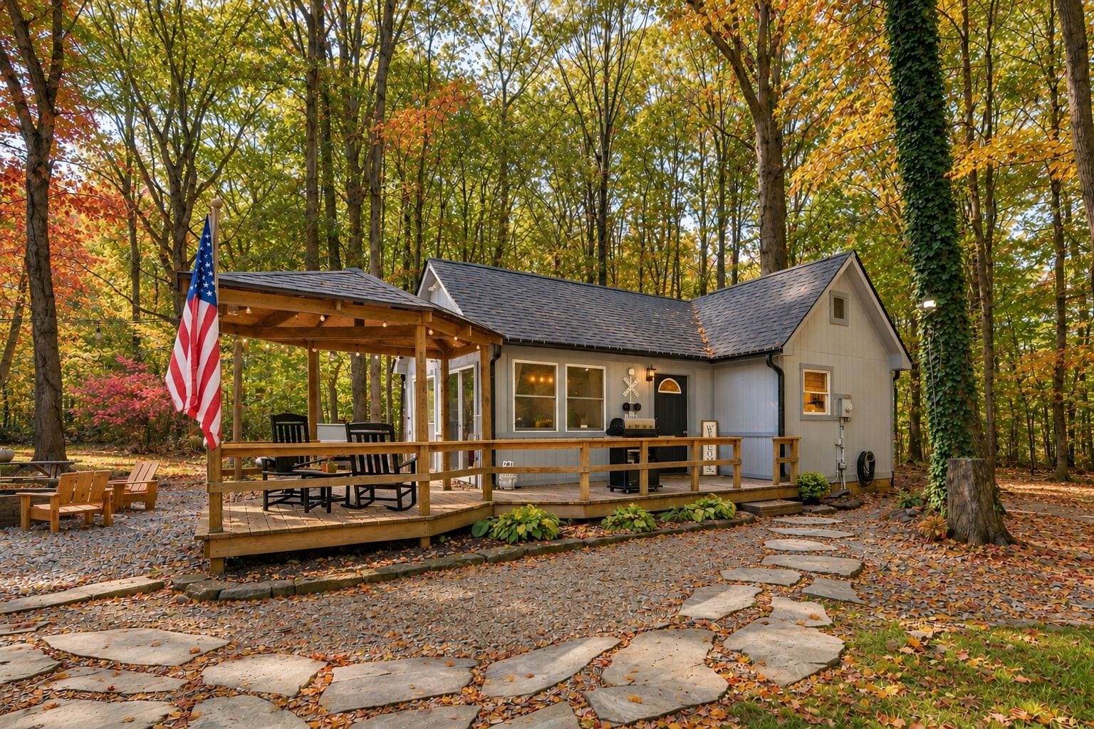 A cabin with a covered porch, outdoor seating, and a flag.