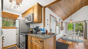 A kitchen with wooden cabinets, a microwave, and a coffee bar. - A Relaxation Station (Morgantown)