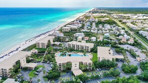 A coastal resort with beachfront villas, a swimming pool, and a parking area. - High Pointe Overlooking Lagoon Pool, Gulf Views! (Rosemary Beach)