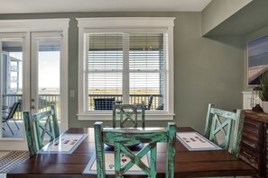 Enjoy meals in this cozy dining area with a table for four, overlooking a balcony with a view.