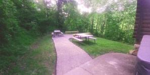 Ein Garten mit Picknicktischen und einem gepflasterten Weg.