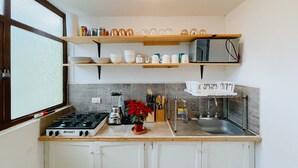 A compact kitchen with a gas stove, a sink, and a countertop with various kitchen items. - 2 Bed in the heart of Cholula with views to the Pyramid and the (San Andrés Cholula)