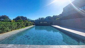 Una piscina trasparente con un edificio moderno sullo sfondo.