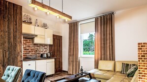 A compact living space with a kitchenette, a sofa, and a dining table.