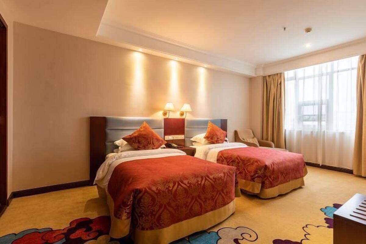 Una habitación de hotel con dos camas, un escritorio y una silla.