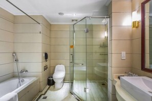 Un baño con ducha de vidrio, bañera y lavabo.