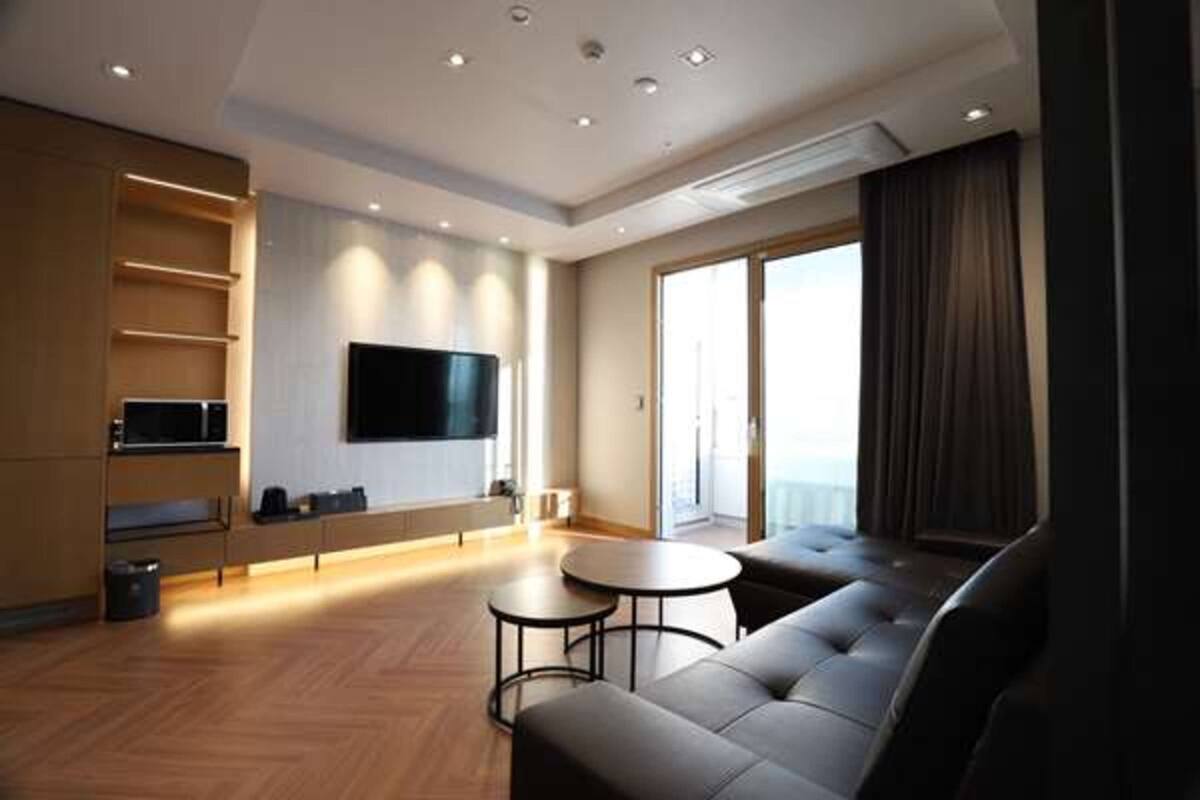 A modern living room with a flat-screen TV, a sofa, and a coffee table.