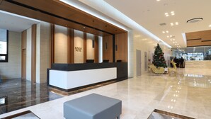 Et moderne hotelværelse med reception, juletræ og siddeområde.