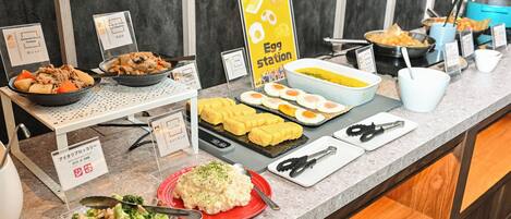 A buffet with various food options including a sign for 'Egg Station', a bowl of soup, and a plate of potato salad.