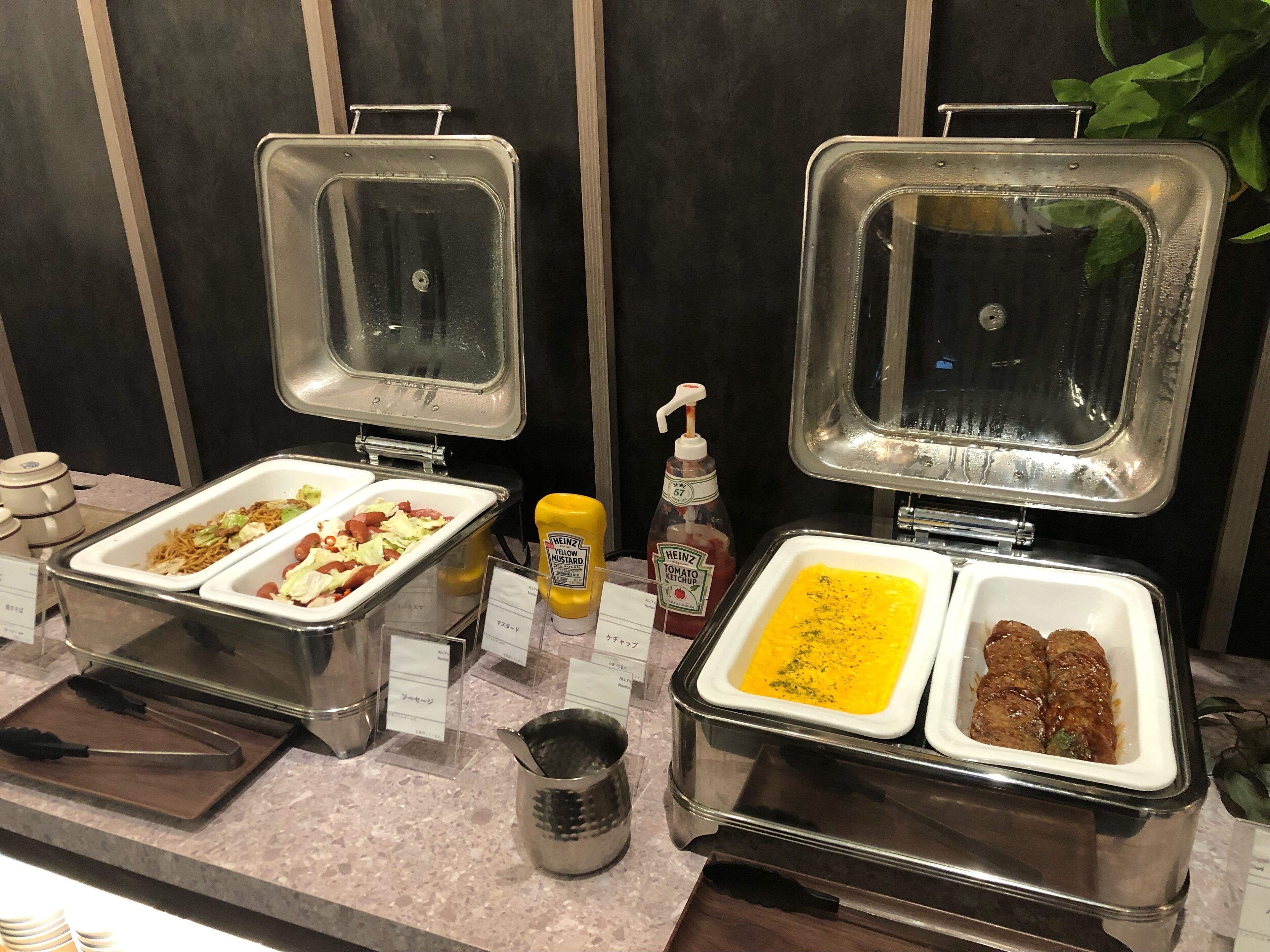 A buffet with various food items and condiments.