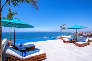 Una piscina al aire libre, sillones reclinables de piscina