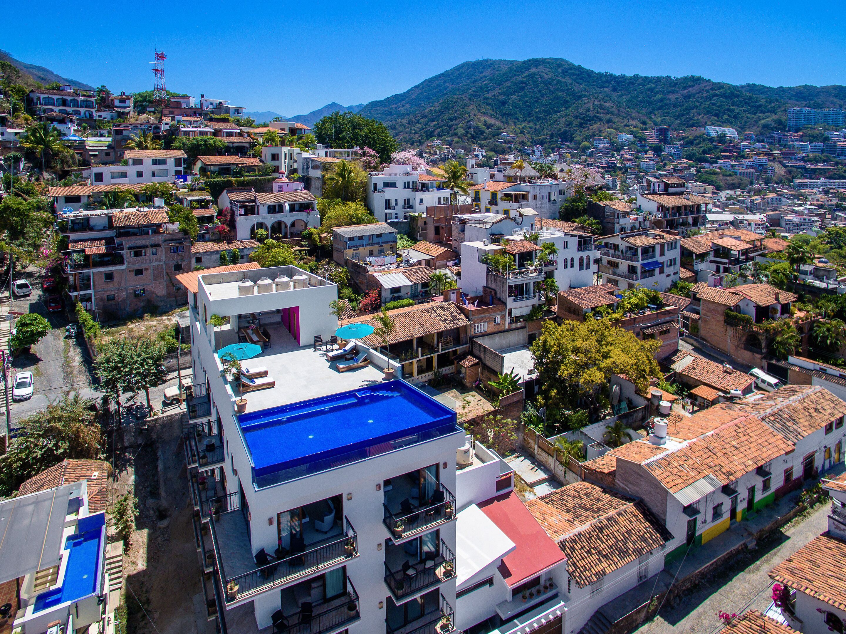 Zona residencial con un edificio destacado que tiene una piscina en la azotea.