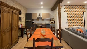 A dining area with a long wooden table, chairs, and a sofa.