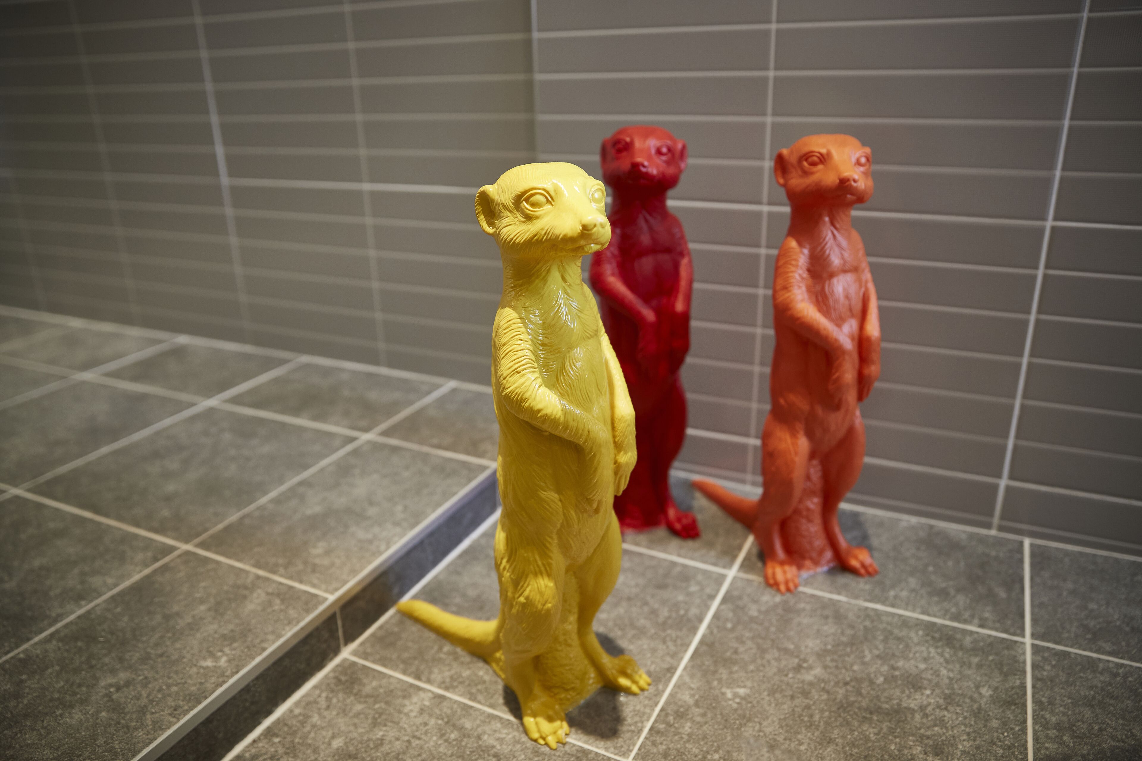 Three animal figurines on a tiled floor.