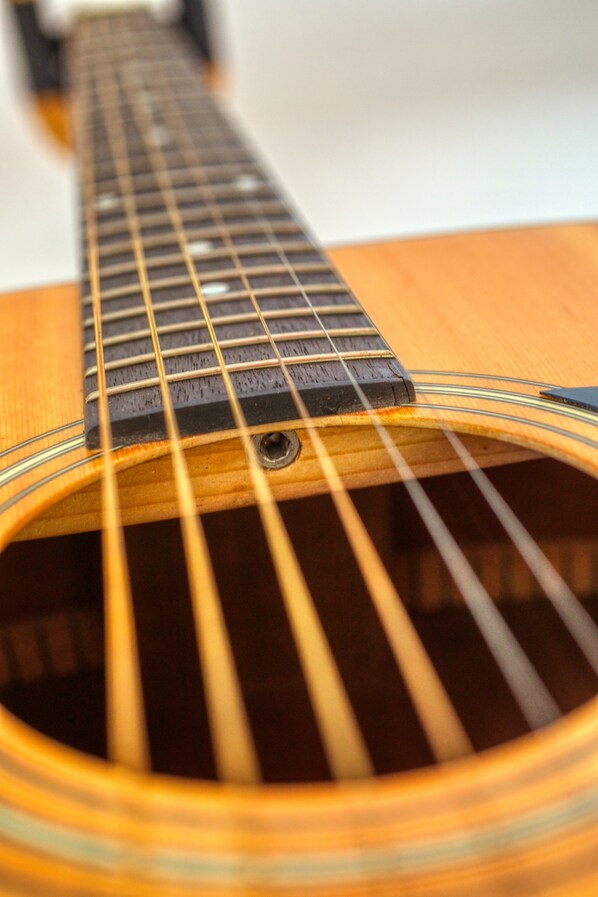 A close-up of an acoustic guitar's neck and fretboard. - Cottage Suite Whirlpool Tub (Madison)