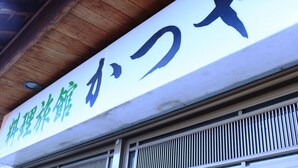 Une enseigne avec des caractères japonais sur la façade d’un immeuble.