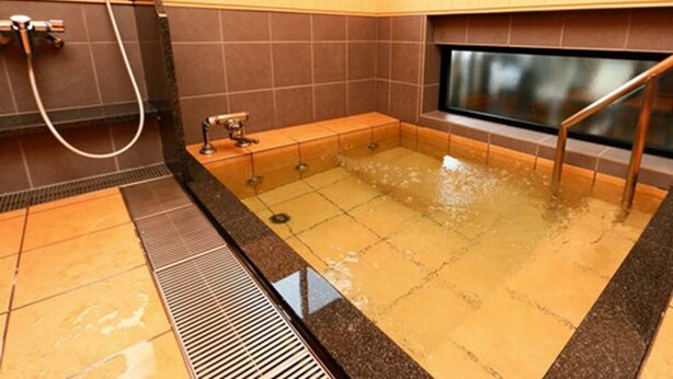 Une salle de bain moderne dotée d’une grande baignoire, d’un espace douche et d’une fenêtre laissant entrer la lumière naturelle.