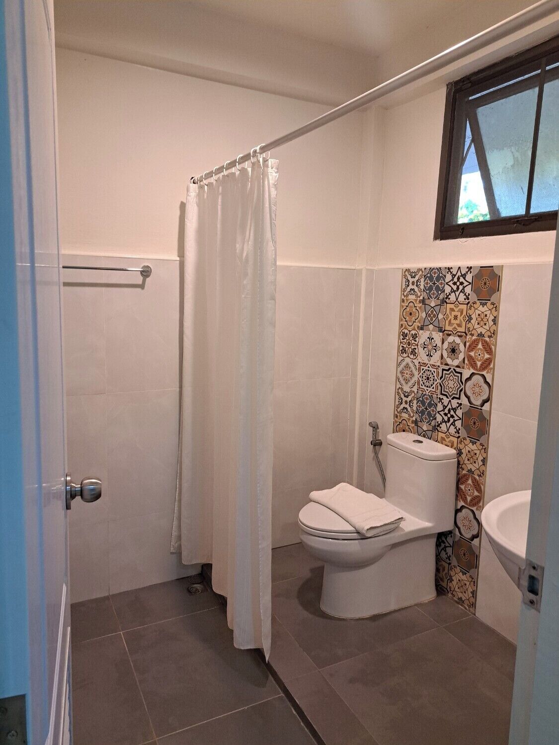 A bathroom with a shower, toilet, and sink.