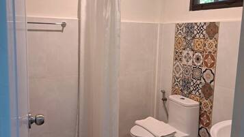 A bathroom with a shower, toilet, and sink.