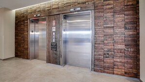 An elevator with a wooden panel design and a sign indicating the floor level.