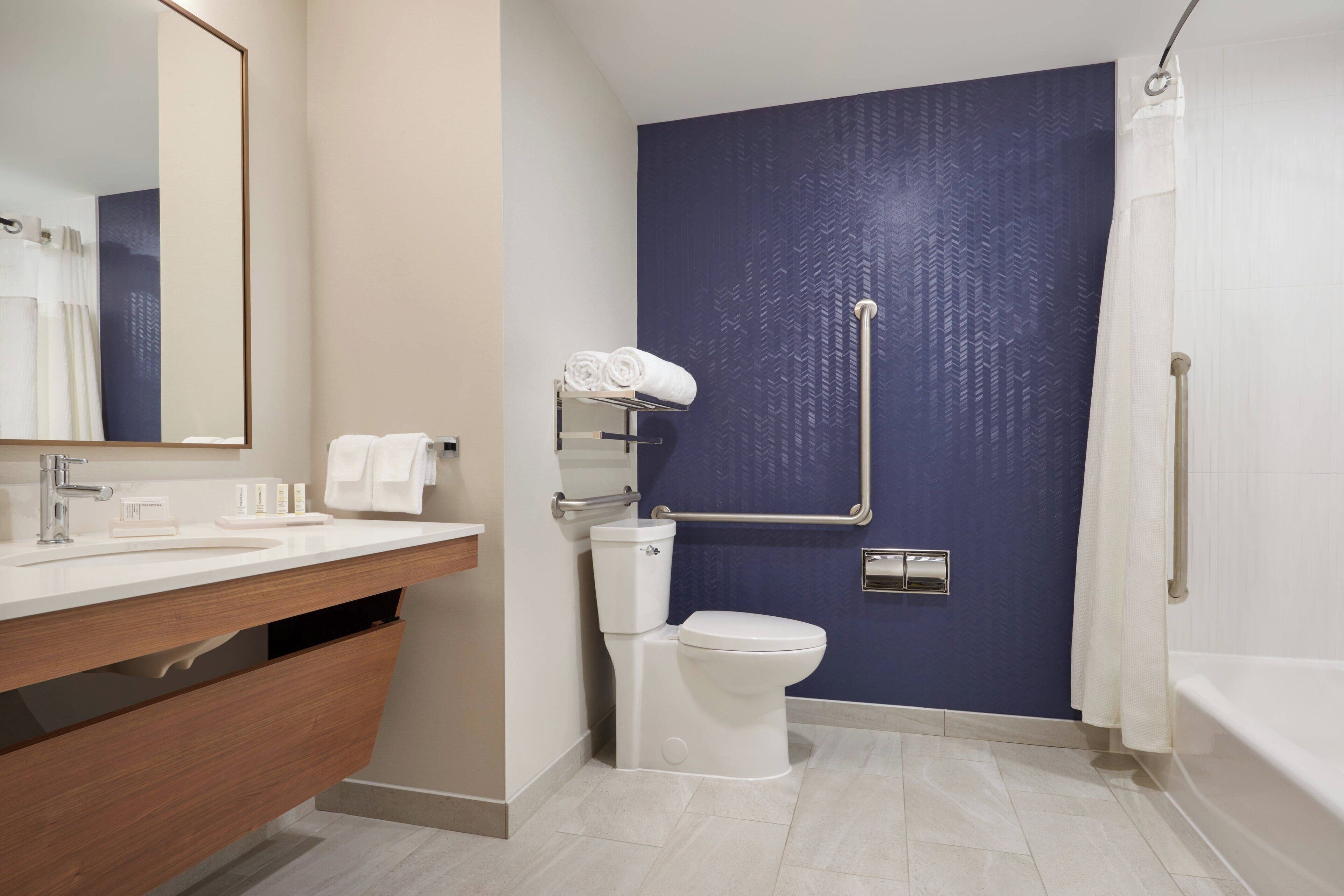 Un baño moderno con lavamanos blanco, inodoro y bañera.