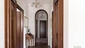 A hallway with wooden doors, a small table with a plant, and a chandelier. - villa Stefano in Moniga del Garda (Moniga del Garda)