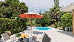 An outdoor dining area with a pool in the background. - villa Stefano in Moniga del Garda (Moniga del Garda)