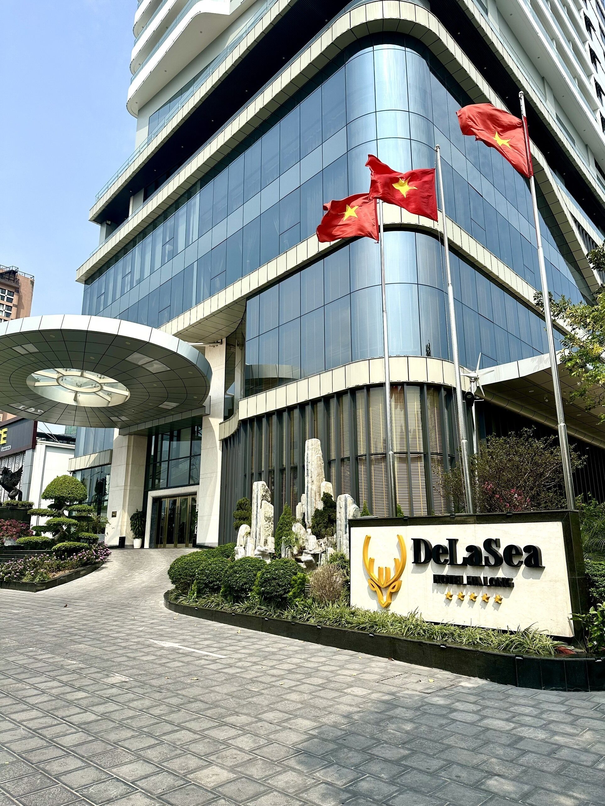 Un bâtiment moderne avec une entrée incurvée et une enseigne indiquant « DeLaSea Hotel ».